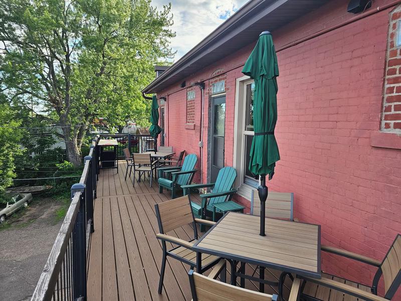 The upper deck — table seating and Adirondack chairs above the river