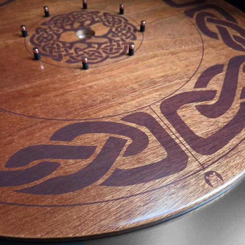 The Lodge's Crokinole board — Celtic knotwork and tree-of-life engraving