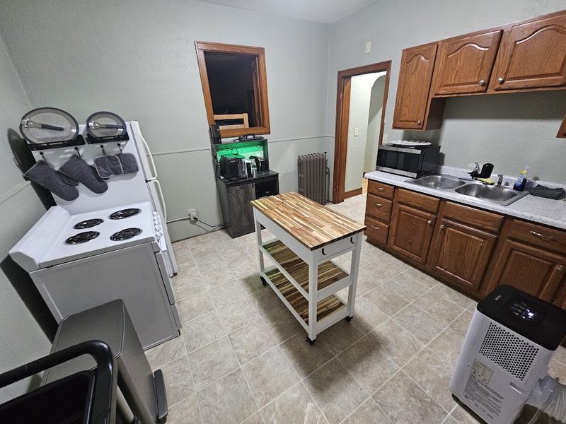 A suite kitchen — full stove, oven, microwave, sink and prep cart